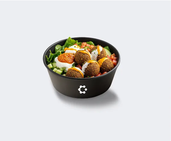 A black bowl with green soup topped with croutons and herbs, featuring a white Circus icon on the front.