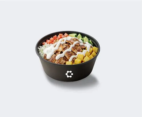 A black bowl with green soup topped with croutons and herbs, featuring a white Circus icon on the front.