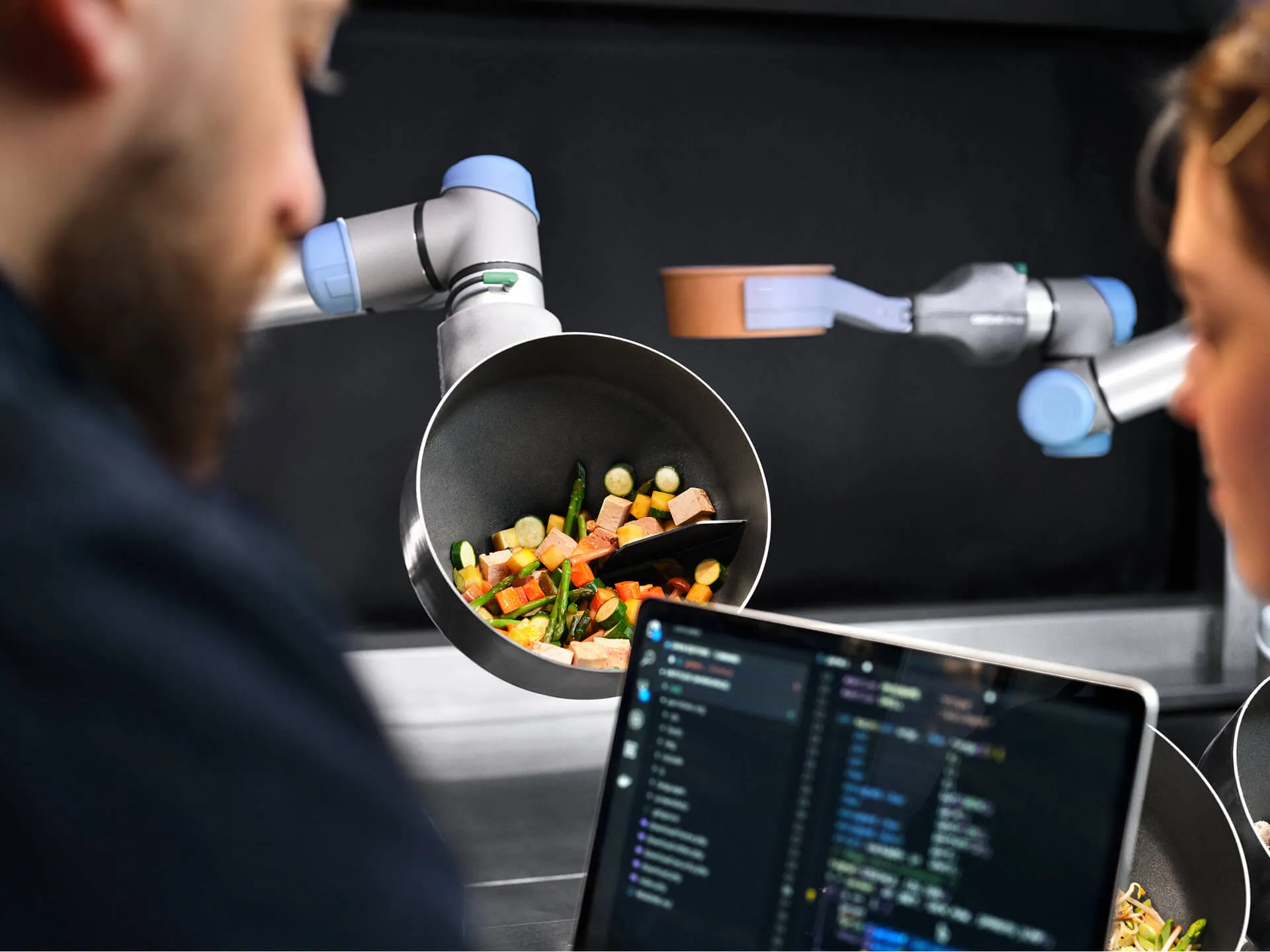 CA-1 robotic arm cooking vegetables while engineers monitor software integration