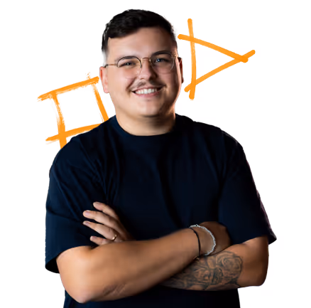 Junger Mann mit Brille und schwarzem T-Shirt, verschränkte Arme, lächelnd, tätowierter Unterarm.