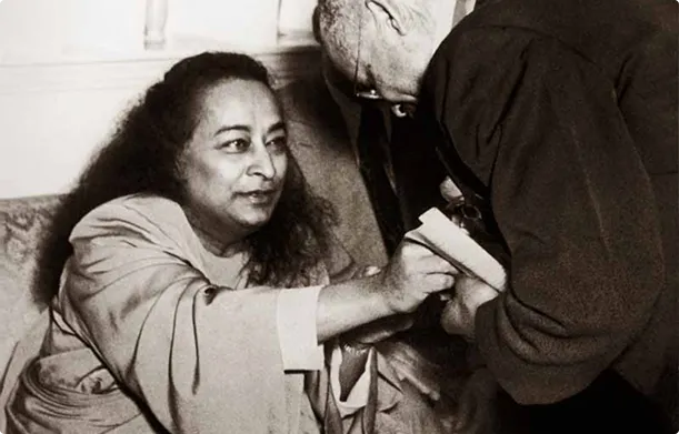 Paramahansa Yogananda seated and another person leaning forward.