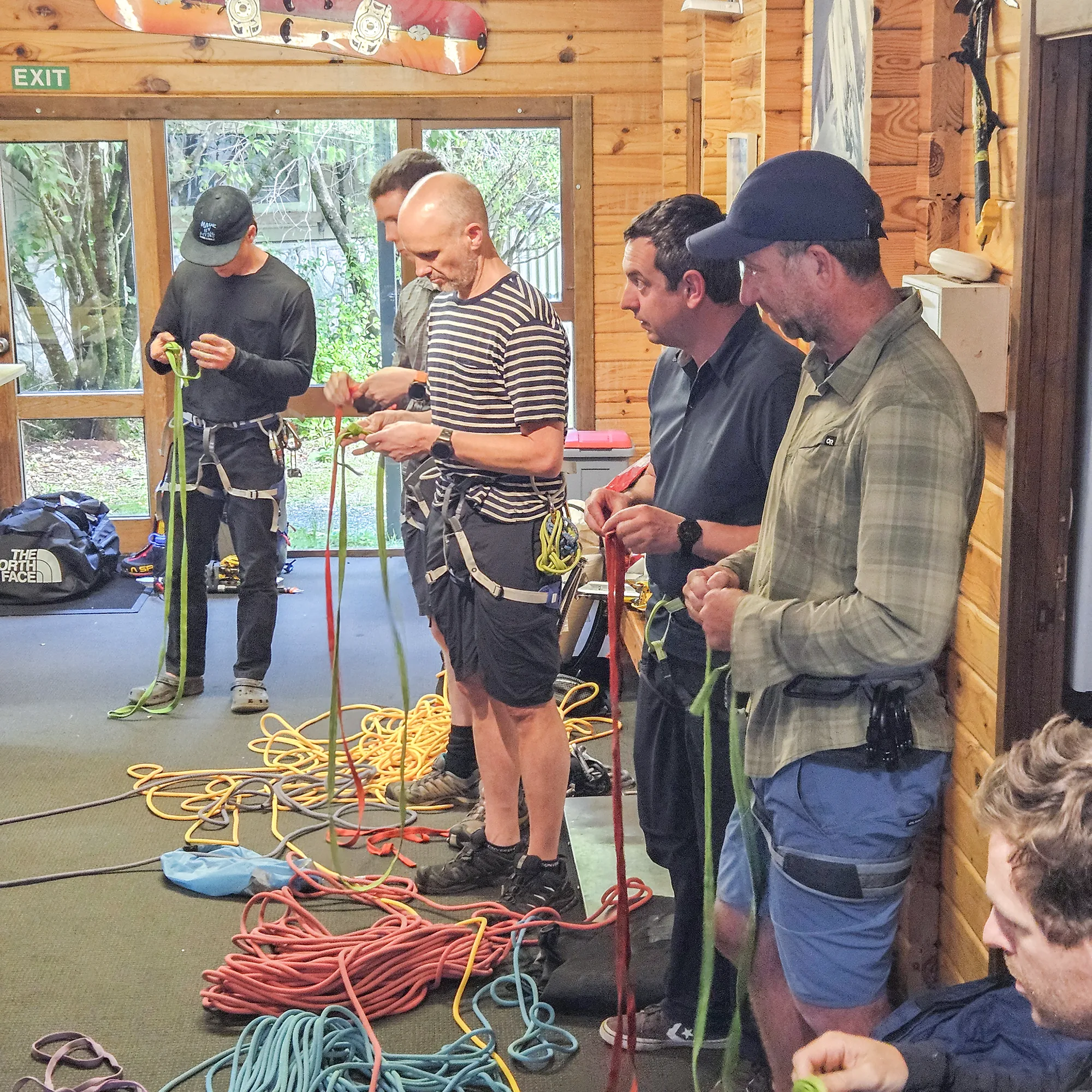 Climbers training indoors to build skills before heading into real alpine environments.