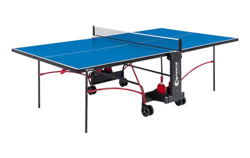 Niebieski stół do tenisa stołowego z czarną ramą i czerwonymi elementami, wyposażony w siatkę i dwa czerwone rakietki.