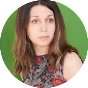 Woman with long brown hair wearing a floral sleeveless top against a green background.