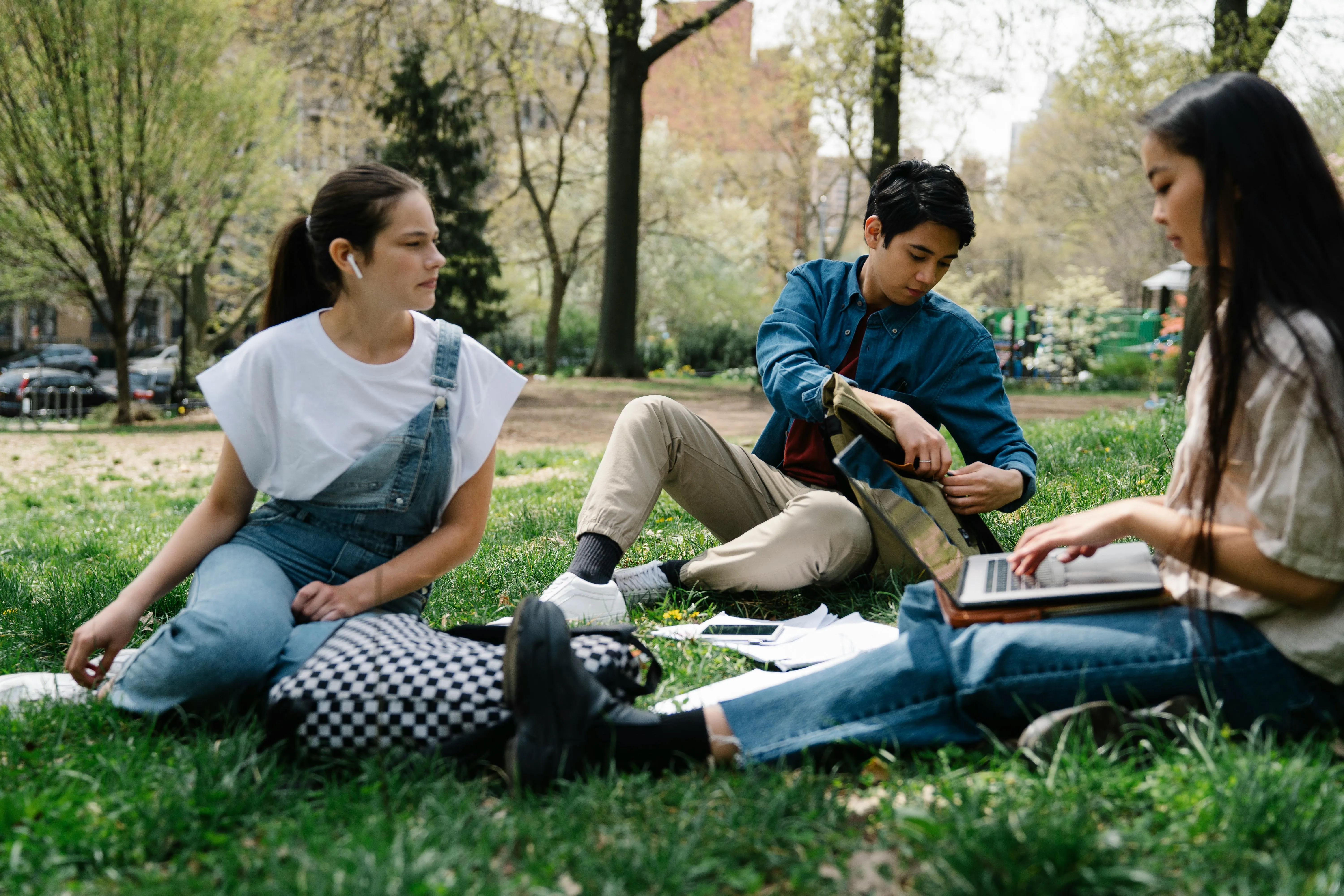 Three UK students sitting outside talking about their experiences.