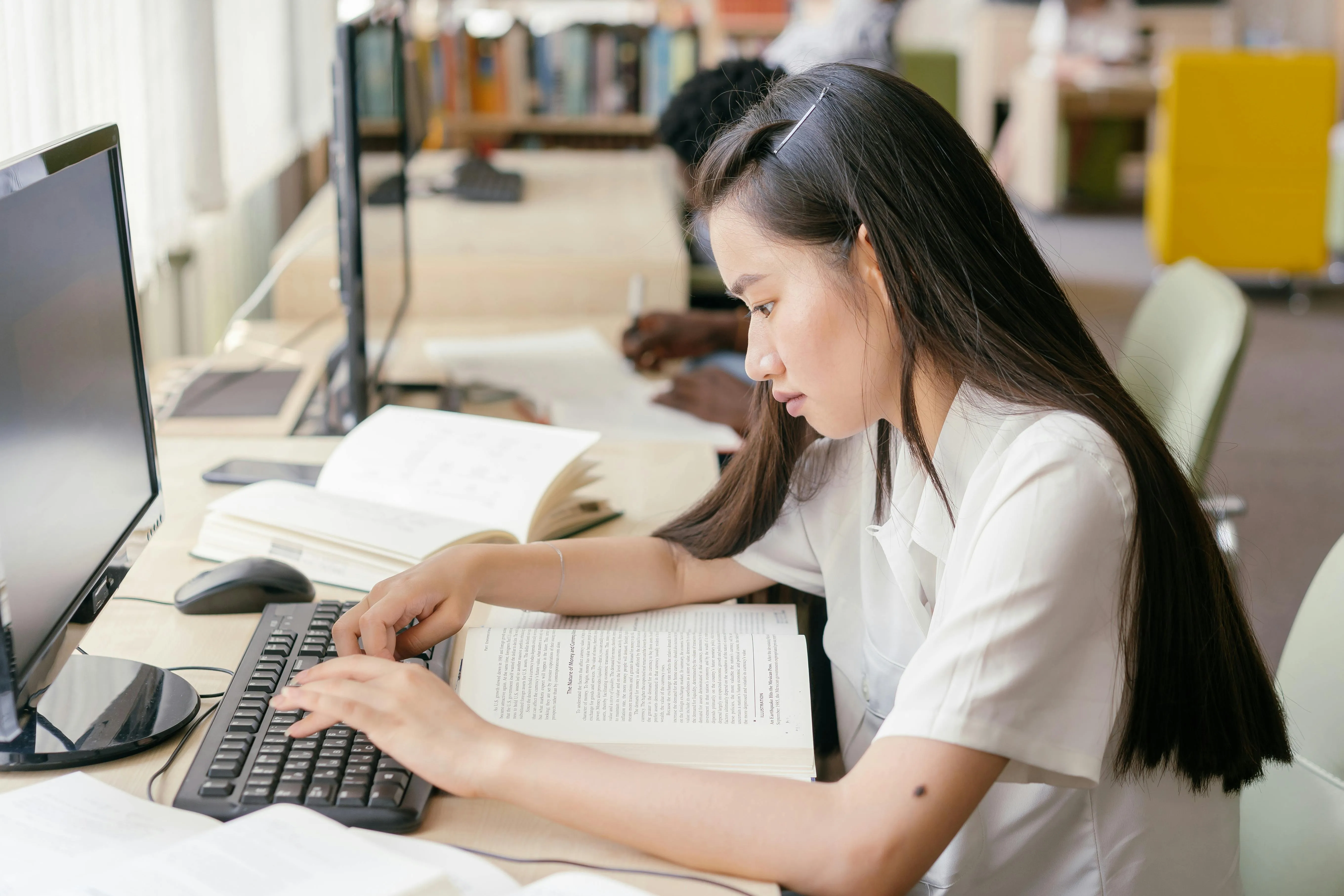 A high school student working on her US college applications at her computer.
