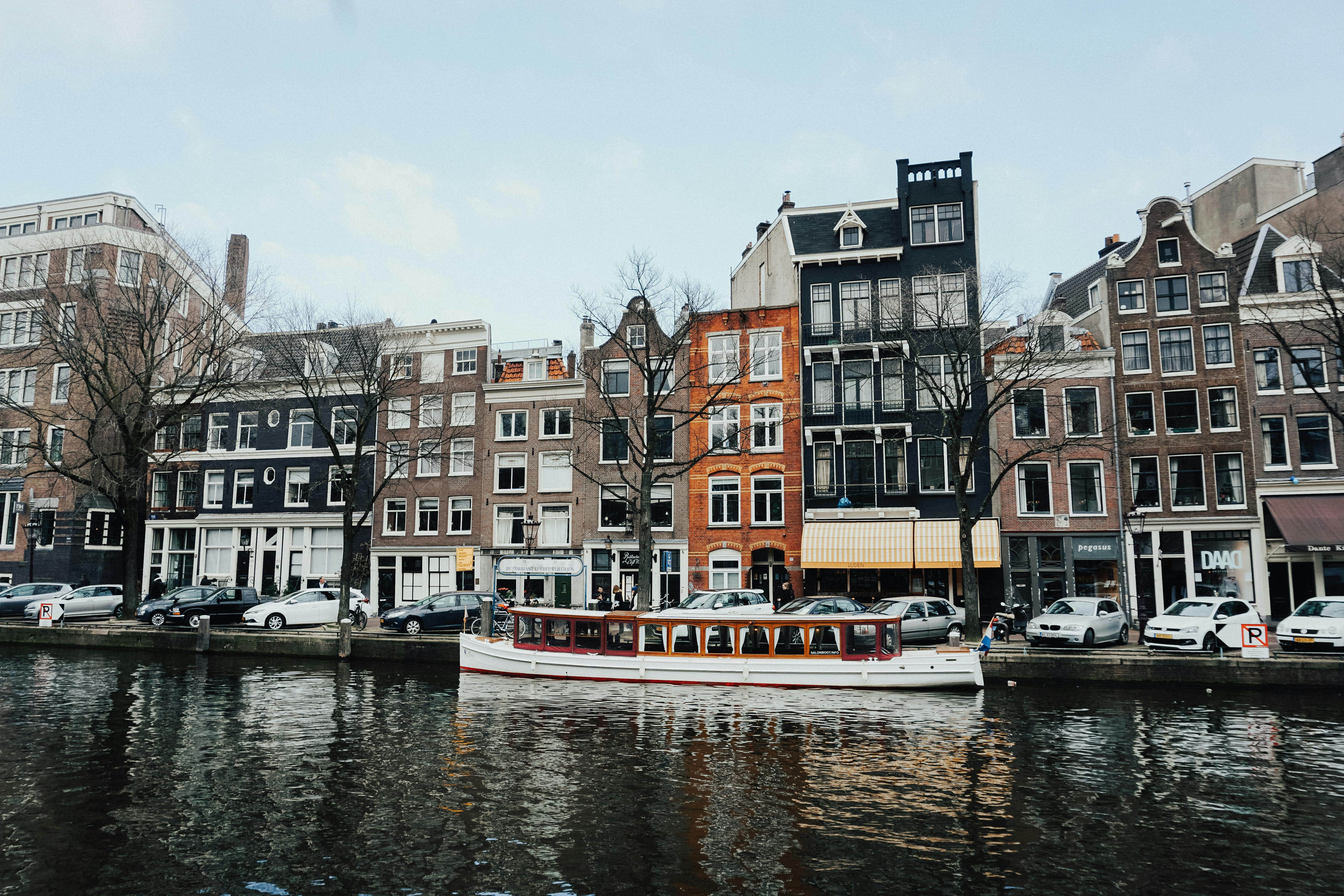 A boat in a canal in front of building in Amsterdam.