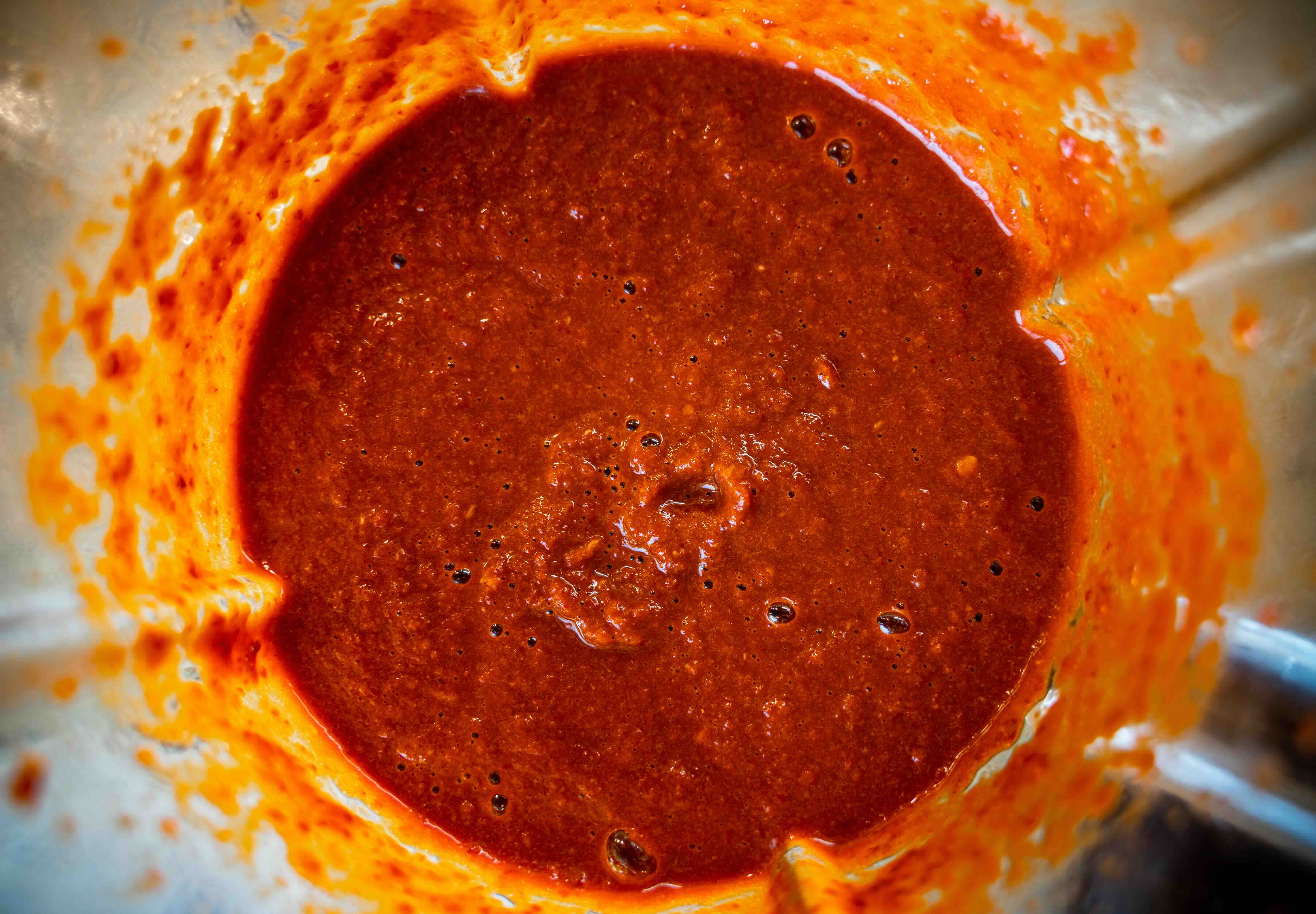Close-up of freshly blended red salsa inside of a blender.
