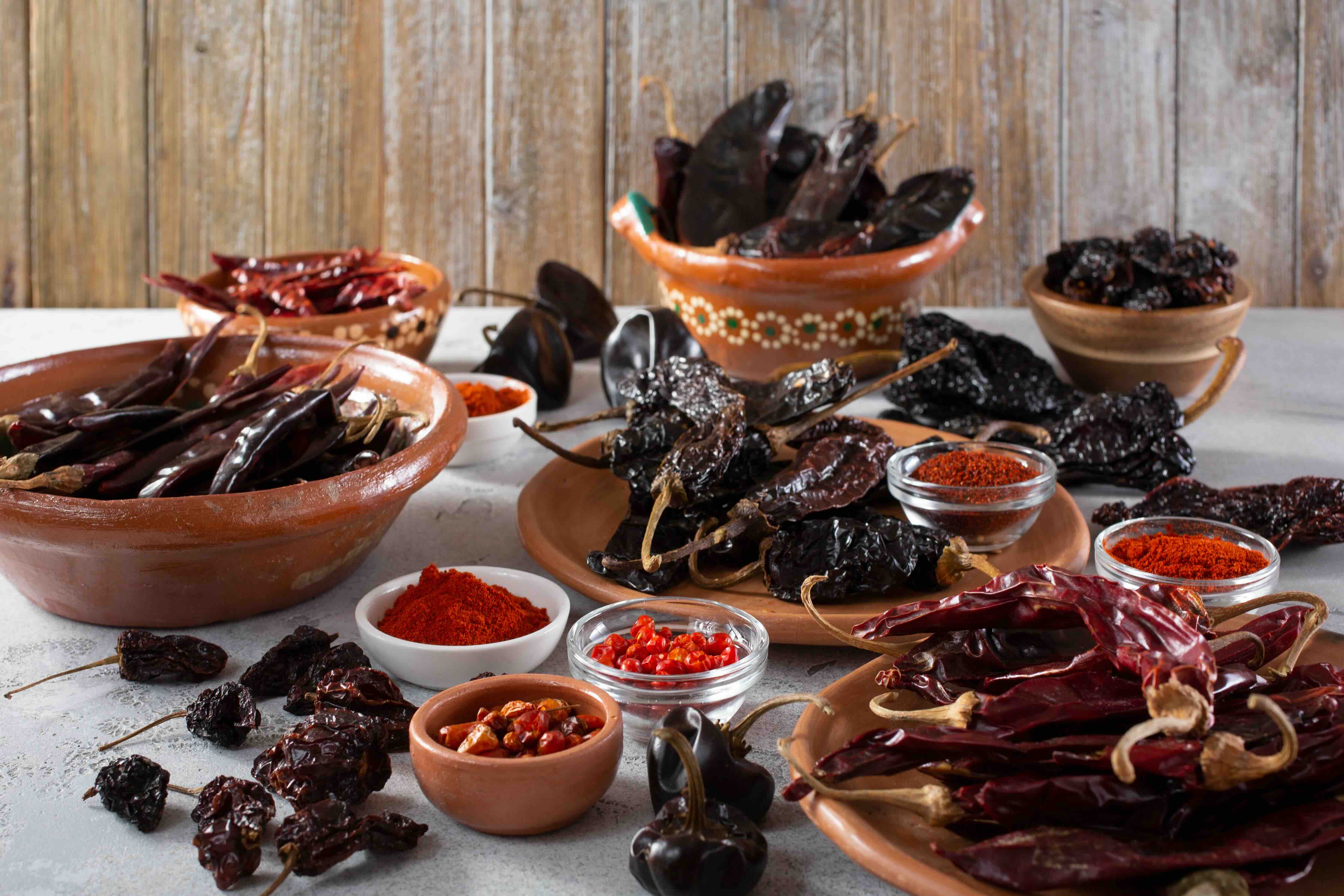 A variety of dried chiles including guajillo, ancho, pasilla, and cascabel.
