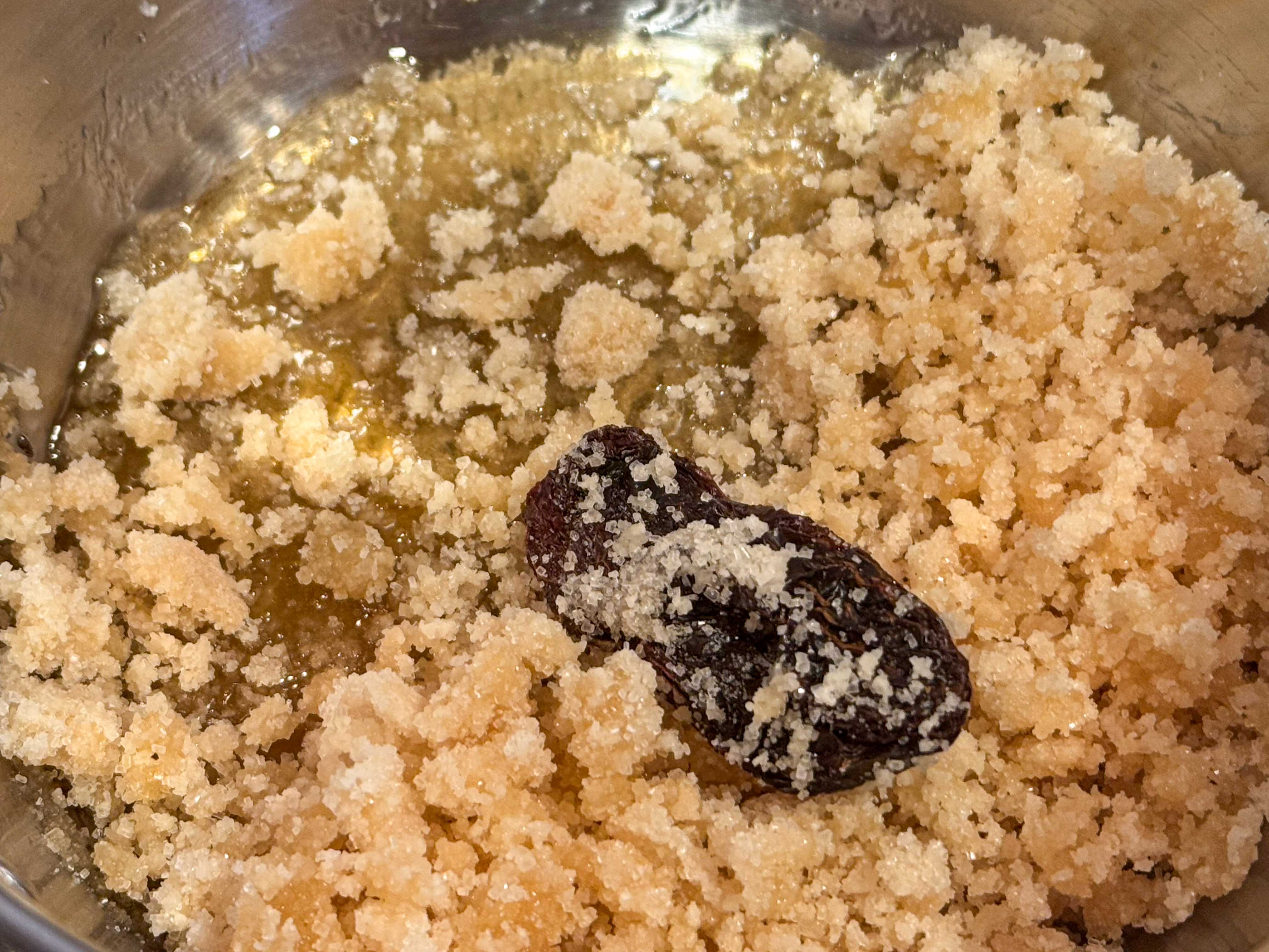Sugar beginning to melt in a saucepan with a morita chile.