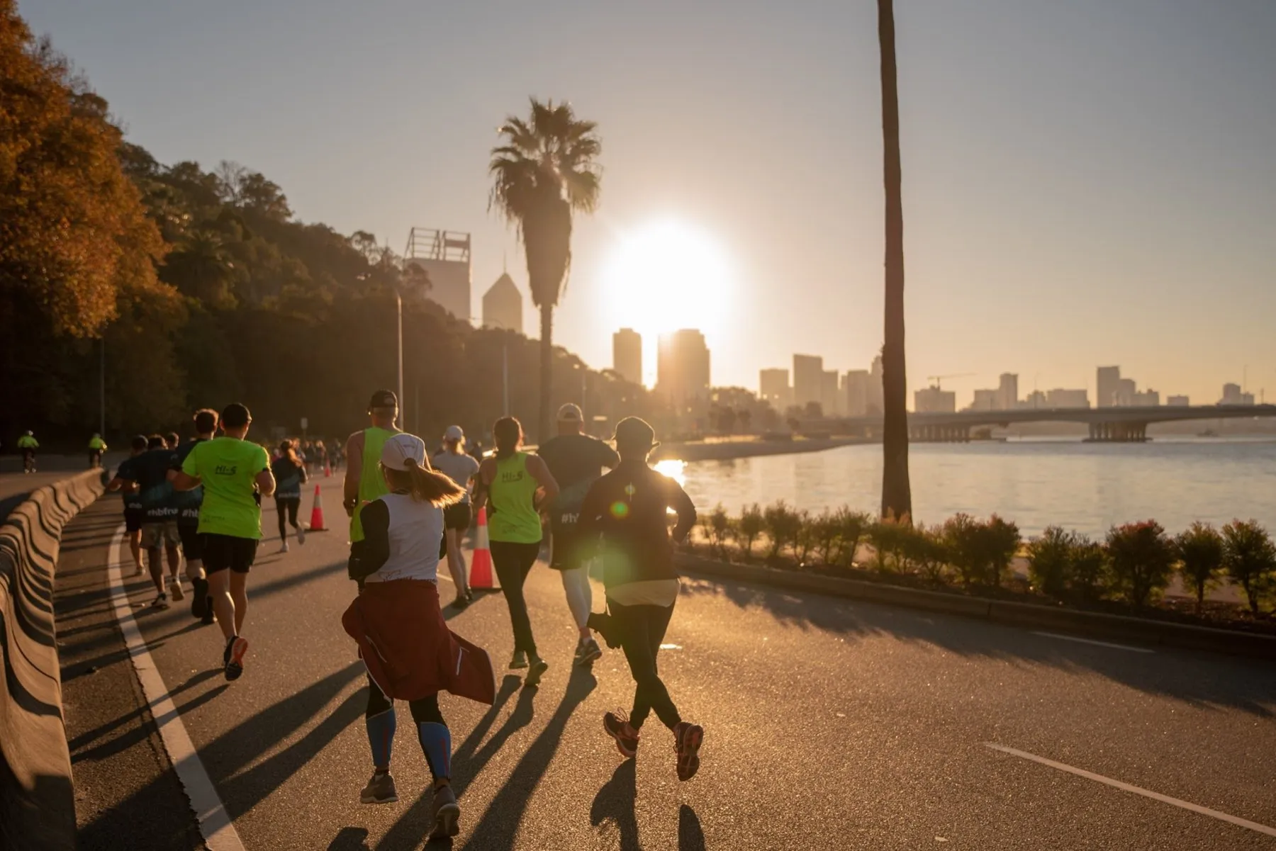 Runners at sunrise on Riverside Drive with the Perth skyline behind them