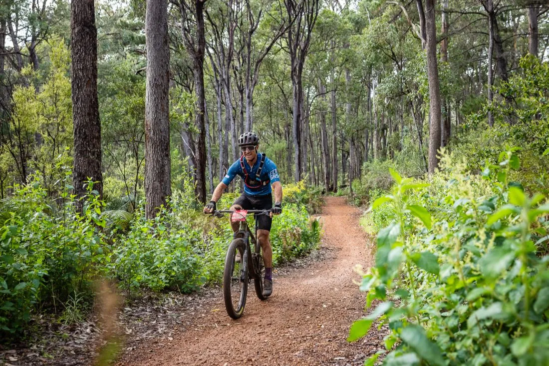 Mountain biker riding singletrack through jarrah forest