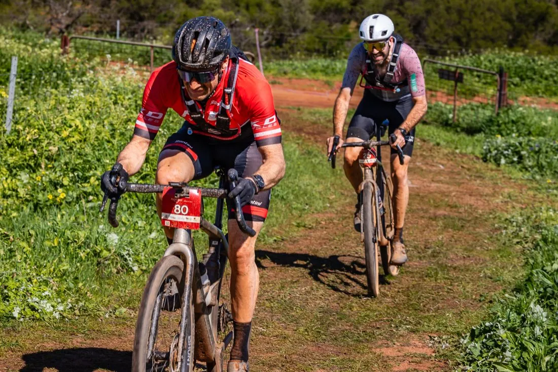 Gravel riders racing on a red dirt road in Chapman Valley