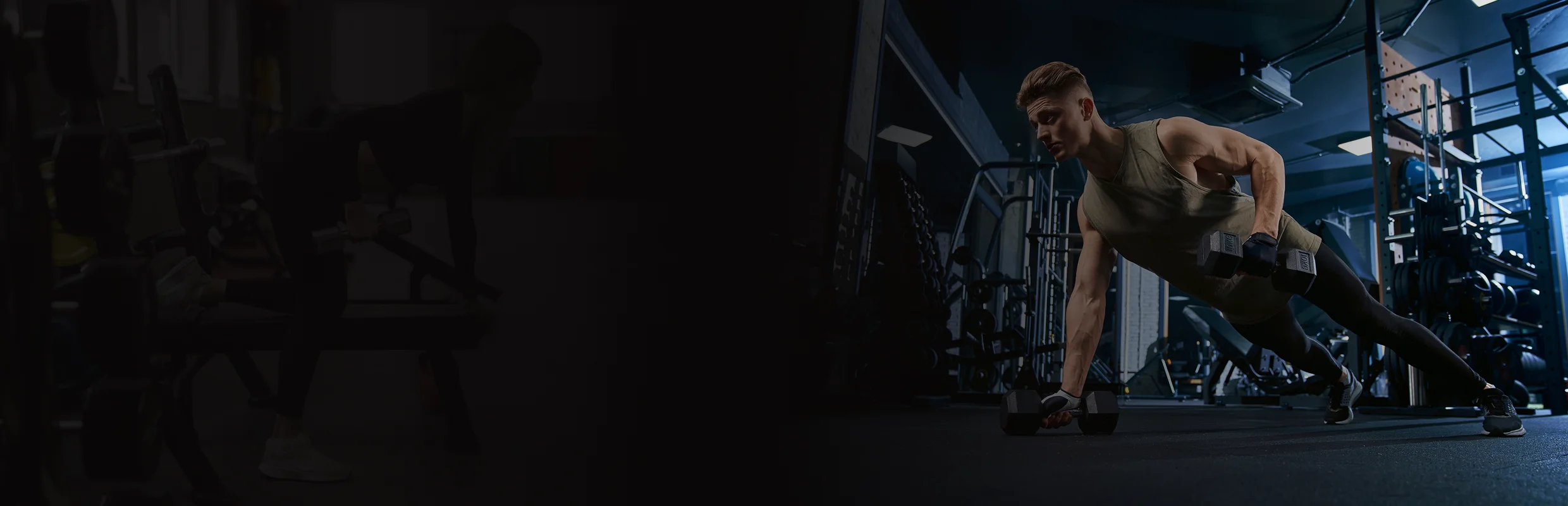 Man performing renegade row exercise holding dumbbells in a gym.