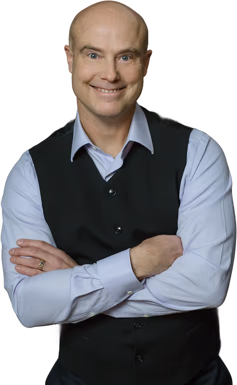 Ben Morley with light blue shirt and black vest, arms crossed.