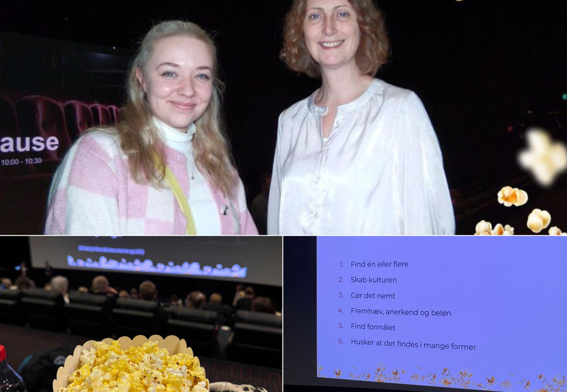 Two smiling women posing indoors at an event, one wearing a pink and white checkered jacket and the other in a white blouse, with a popcorn bucket and a presentation screen visible nearby.