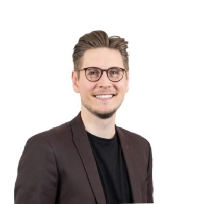 Black and white portrait of a smiling woman with long, wavy hair.