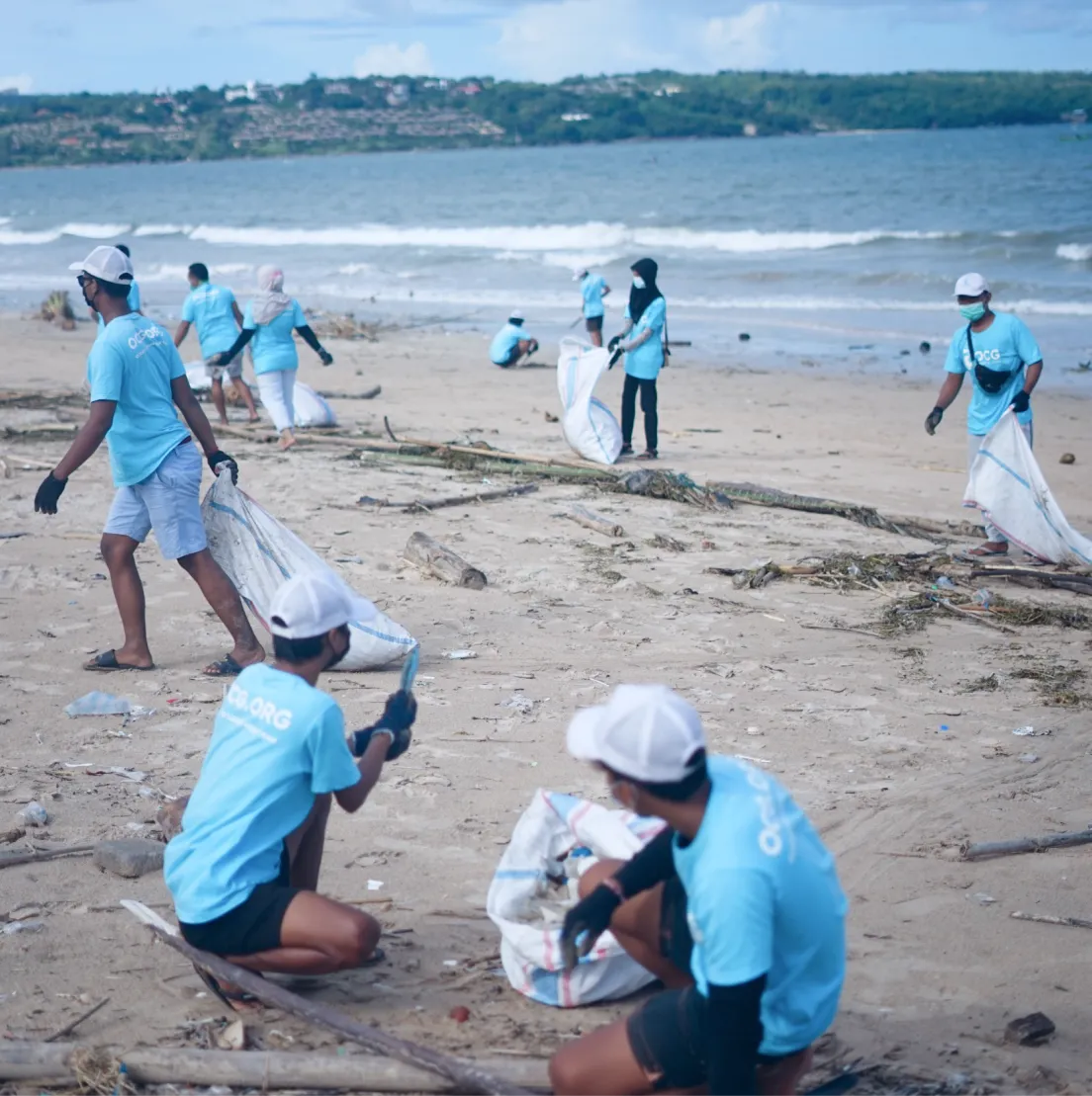 a group of people picking up trash on a beach - volunteer - best organization website webflow CMS template