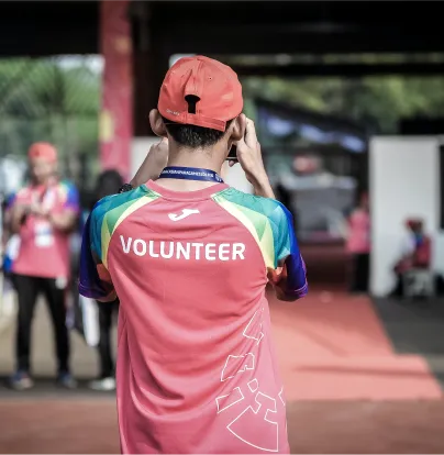 a man in a volunteer shirt is on his cell phone - volunteer - best organization website webflow CMS template