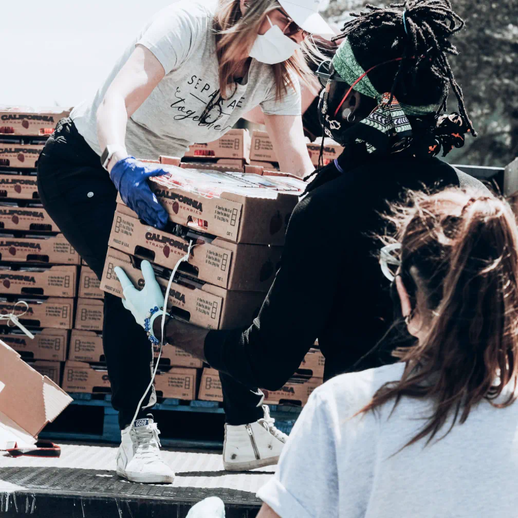 a woman in a white shirt and some boxes - volunteer - best organization website webflow CMS template