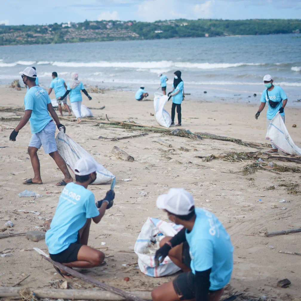 a group of people picking up trash on a beach - volunteer - best organization website webflow CMS template