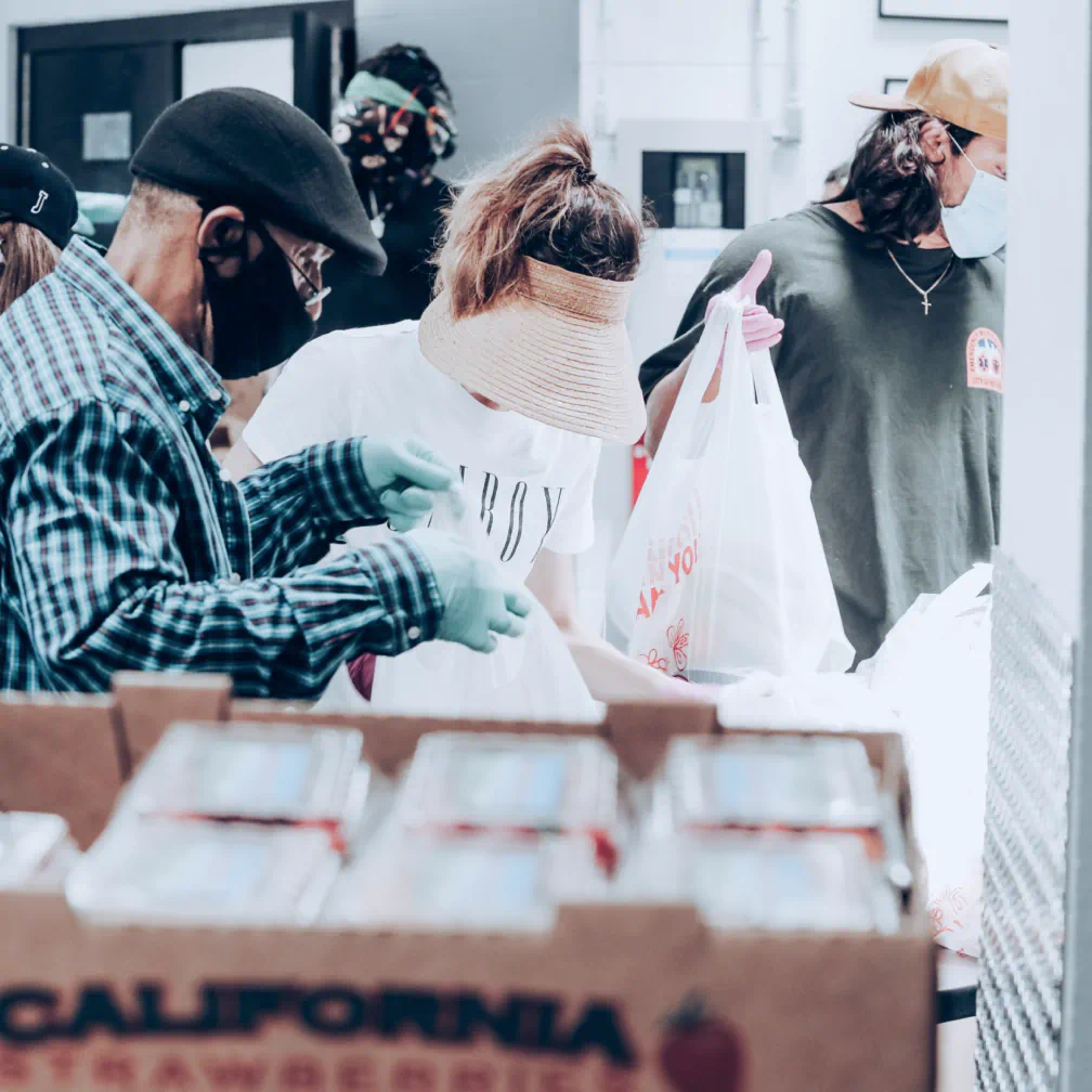 a group of people standing around a box of cards - volunteer - best organization website webflow CMS template