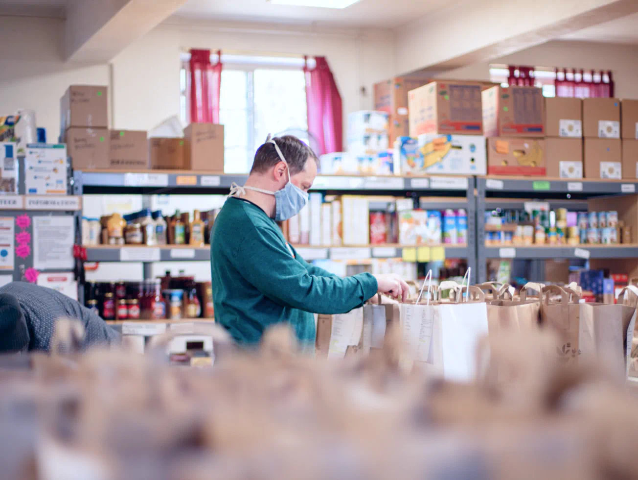 a man wearing a face mask in a grocery store - volunteer - best organization website webflow CMS template