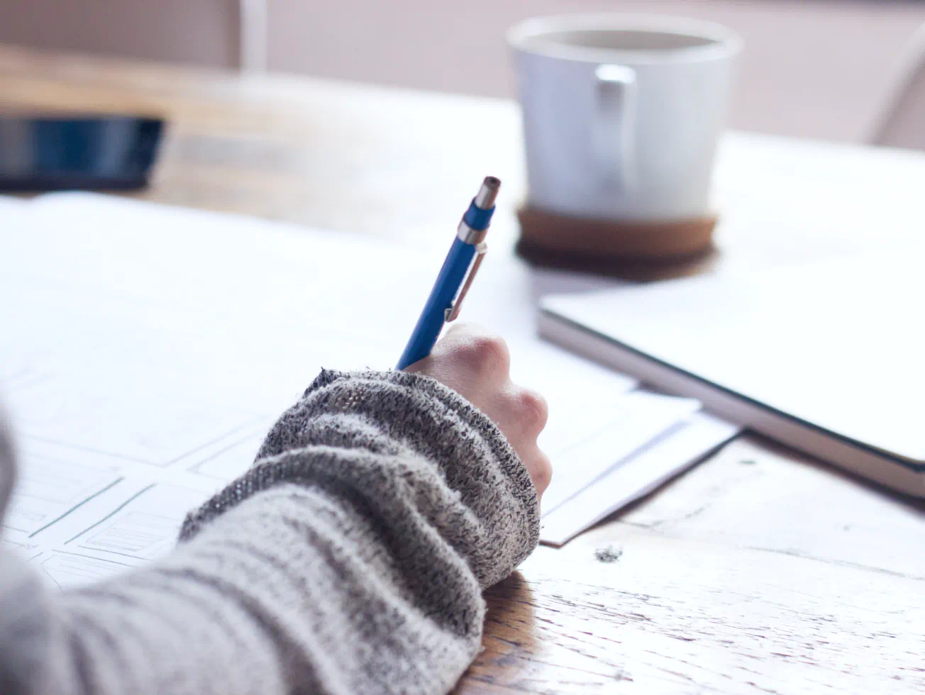 a person writing on a piece of paper with a pen - Volunteer - Best Organization Website Webflow CMS Template