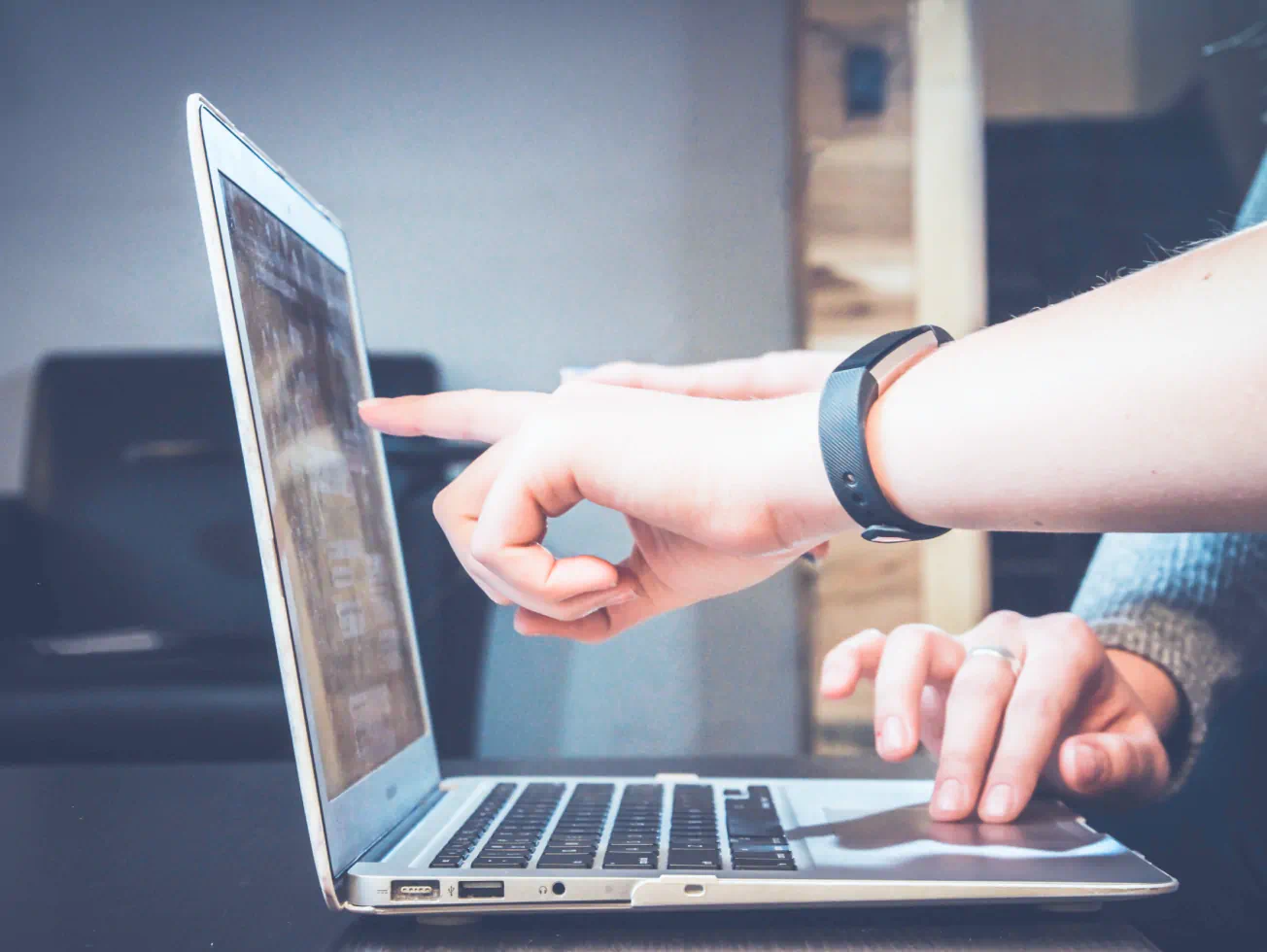 a person pointing at a laptop on a table - volunteer - best organization website webflow CMS template