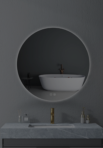 Round illuminated bathroom mirror above a marble sink with gold faucet and accessories.