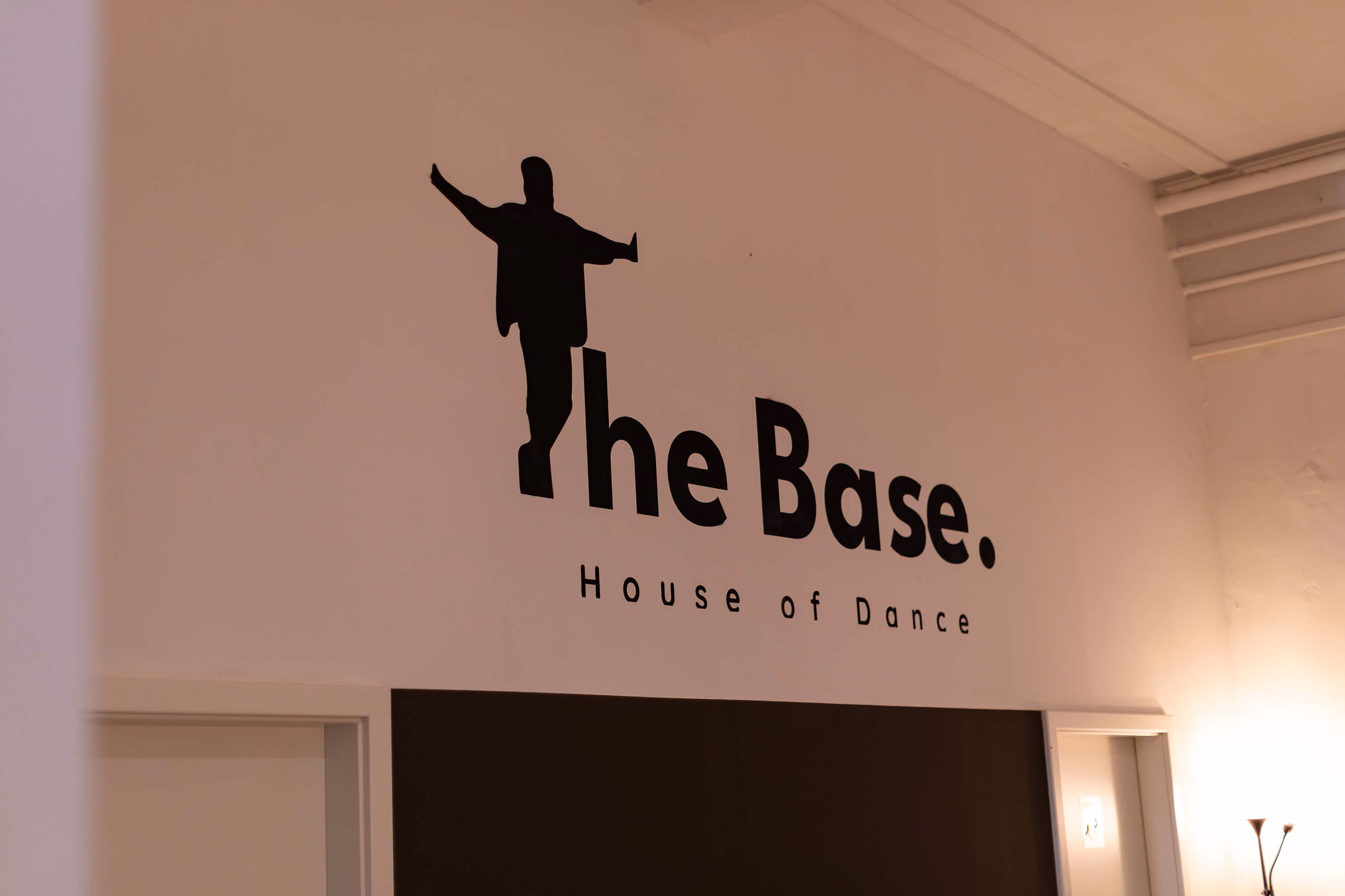 Innenwand der Tanzschule The Base Erfurt mit Tänzer-Silhouette und dem Schriftzug „The Base. House of Dance“