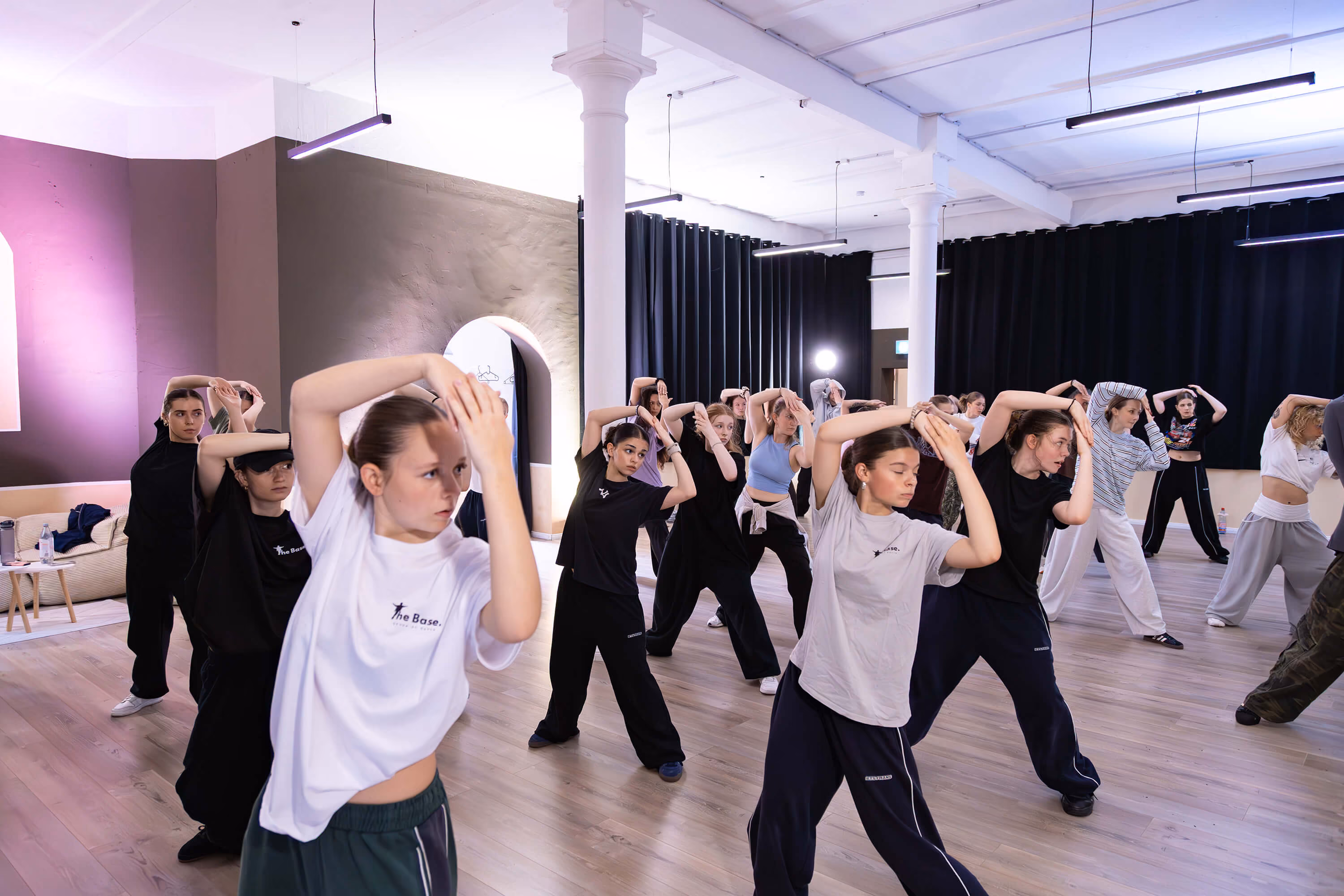Gruppe junger Tänzerinnen und Tänzer trainiert gemeinsam eine Choreografie im großen Tanzstudio von The Base Erfurt.
