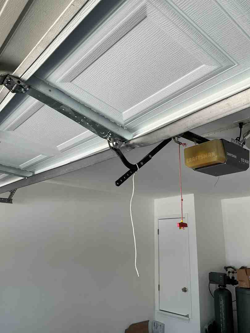 A homeowner testing the garage door's auto-reverse sensors with an object placed in the door's path - garage door maintenance in round rock tx