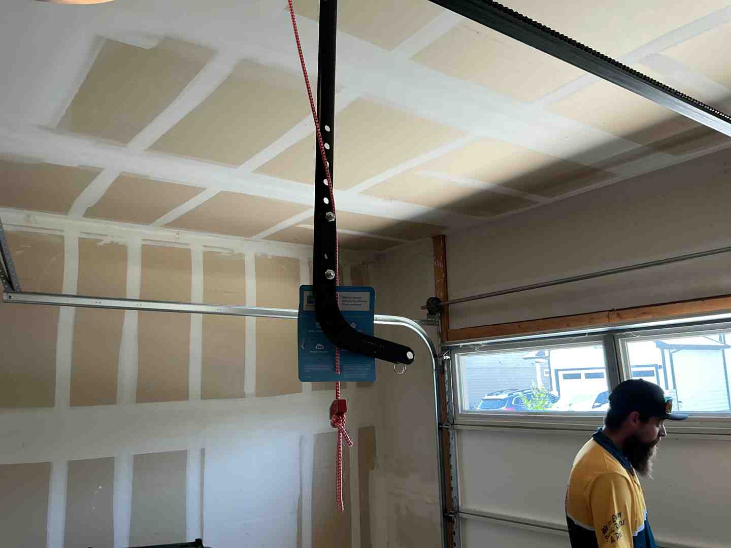 Technicians in professional uniforms carefully aligning a new garage door track inside a residential garage - emergency