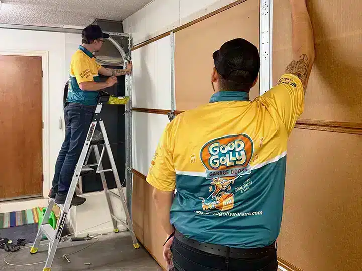 Good Golly Garage Doors techs measuring garage door in residential home