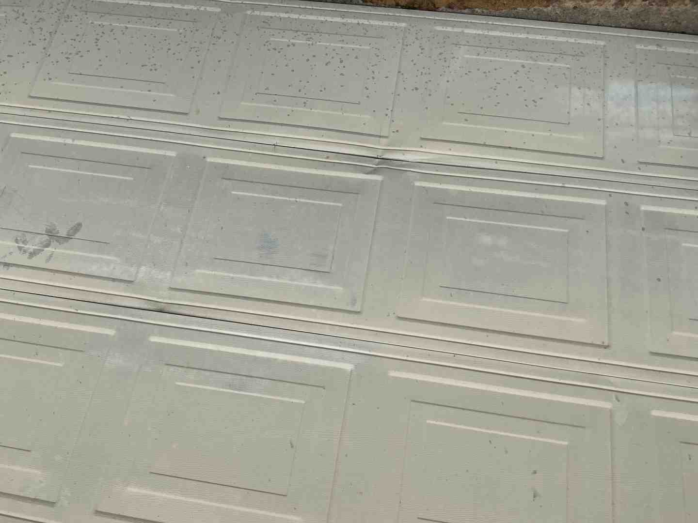 sun-faded garage door panels in a suburban driveway
