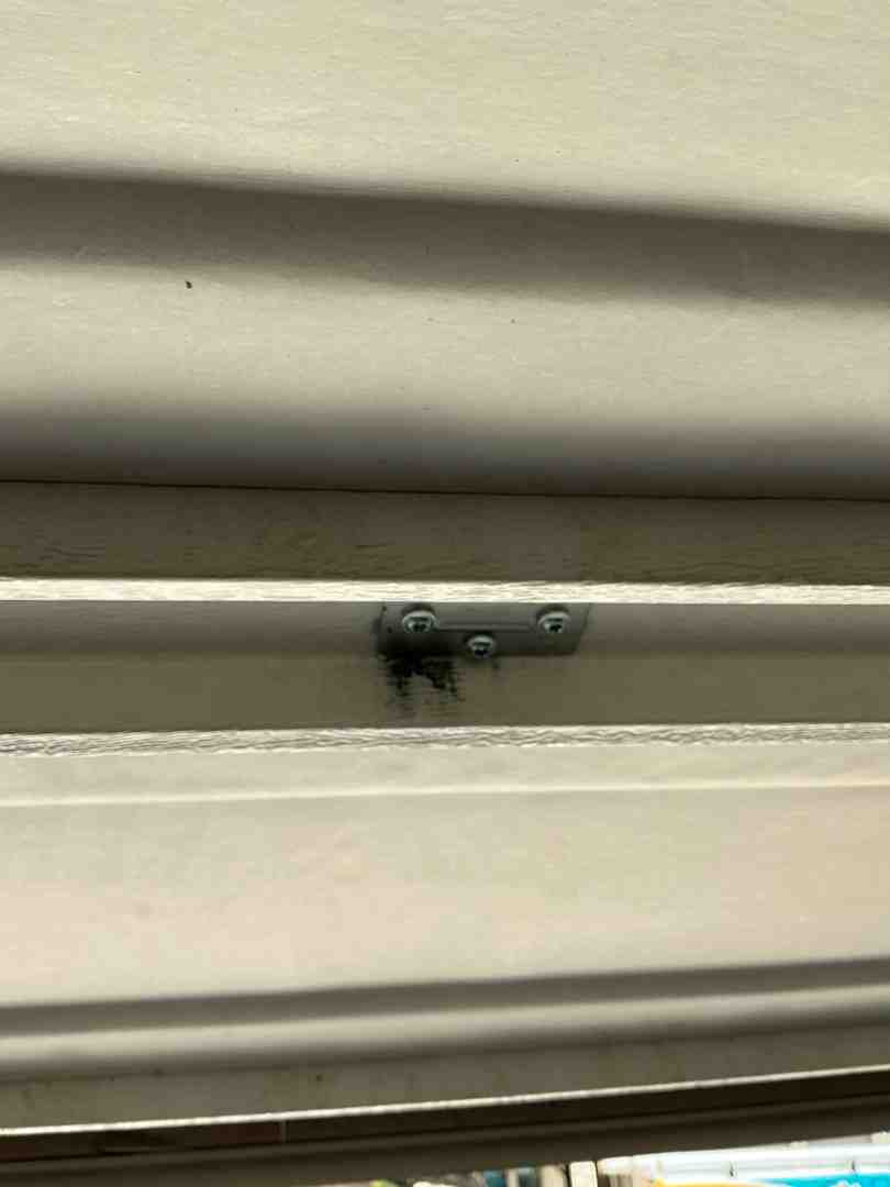 technician applying spray lubricant to garage door hinges and rollers - how climate affects garage door lubrication needs technician applying spray lubricant to garage door hinges and rollers - how climate affects garage door lubrication needs