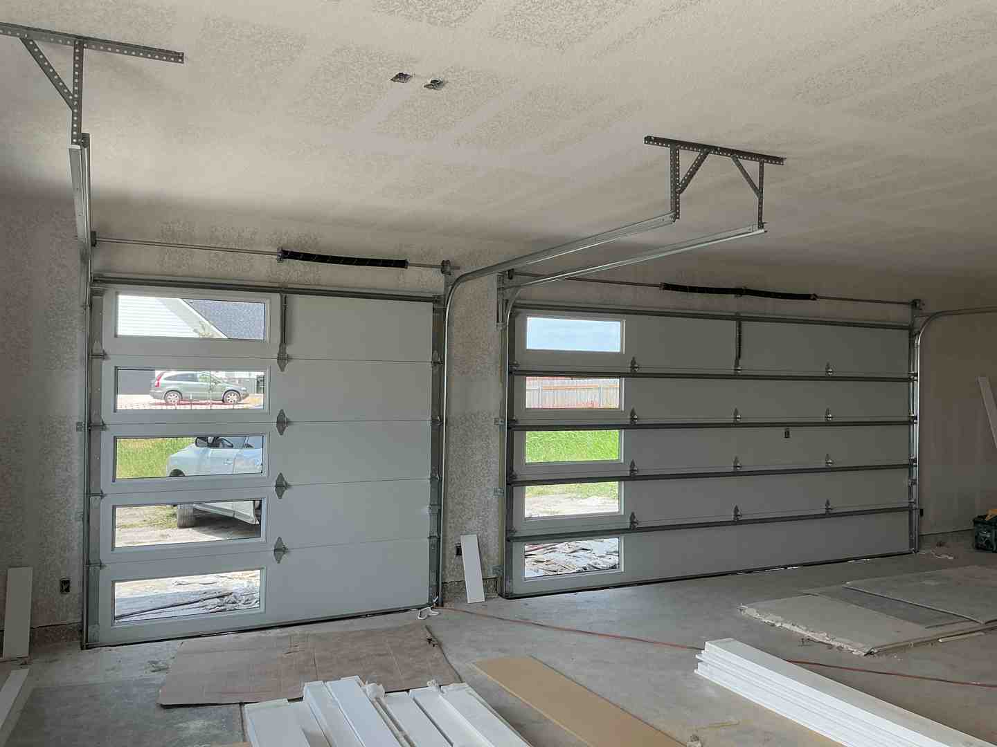 A variety of garage door styles and materials including steel, wood, and glass sectional doors - how much does a new garage