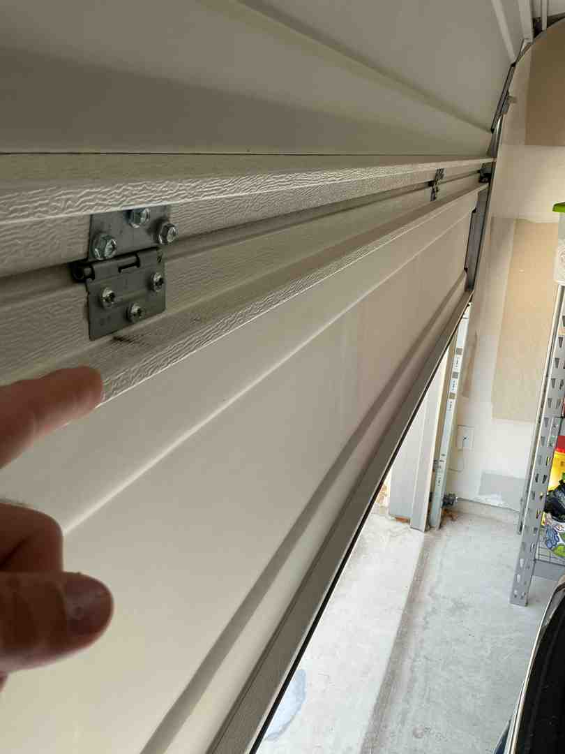 Homeowner safely lubricating garage door hinges with a silicone spray - is it safe to repair a garage door yourself Homeowner safely lubricating garage door hinges with a silicone spray - is it safe to repair a garage door yourself