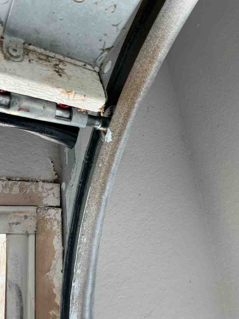 homeowner inspecting garage door tracks