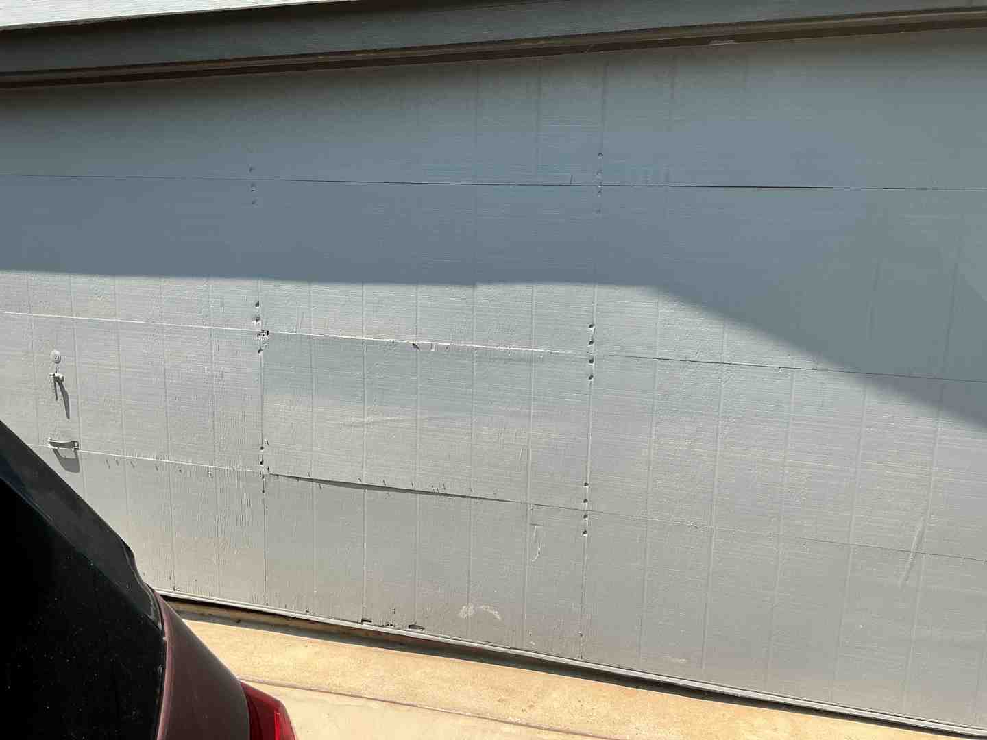Faded and warped garage door panels due to intense Austin sun exposure