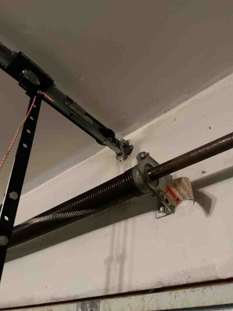 comparison view of a horizontal torsion spring system above the door and extension springs along the side tracks comparison view of a horizontal torsion spring system above the door and extension springs along the side tracks