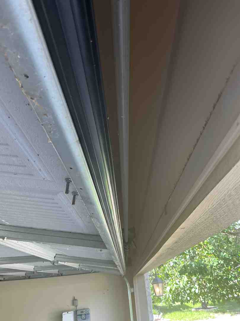 technician inspecting garage door tracks from the inside technician inspecting garage door tracks from the inside