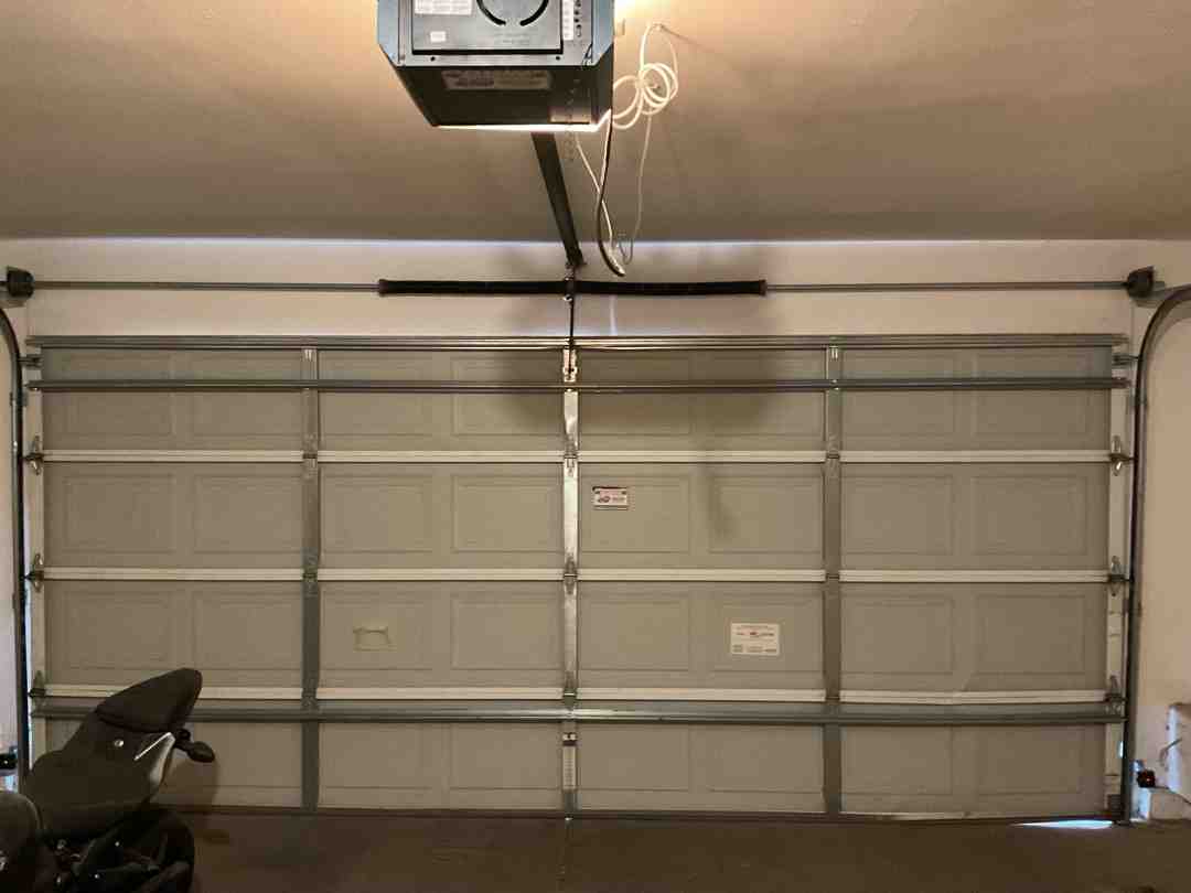 A blocked garage door path with household items near the tracks