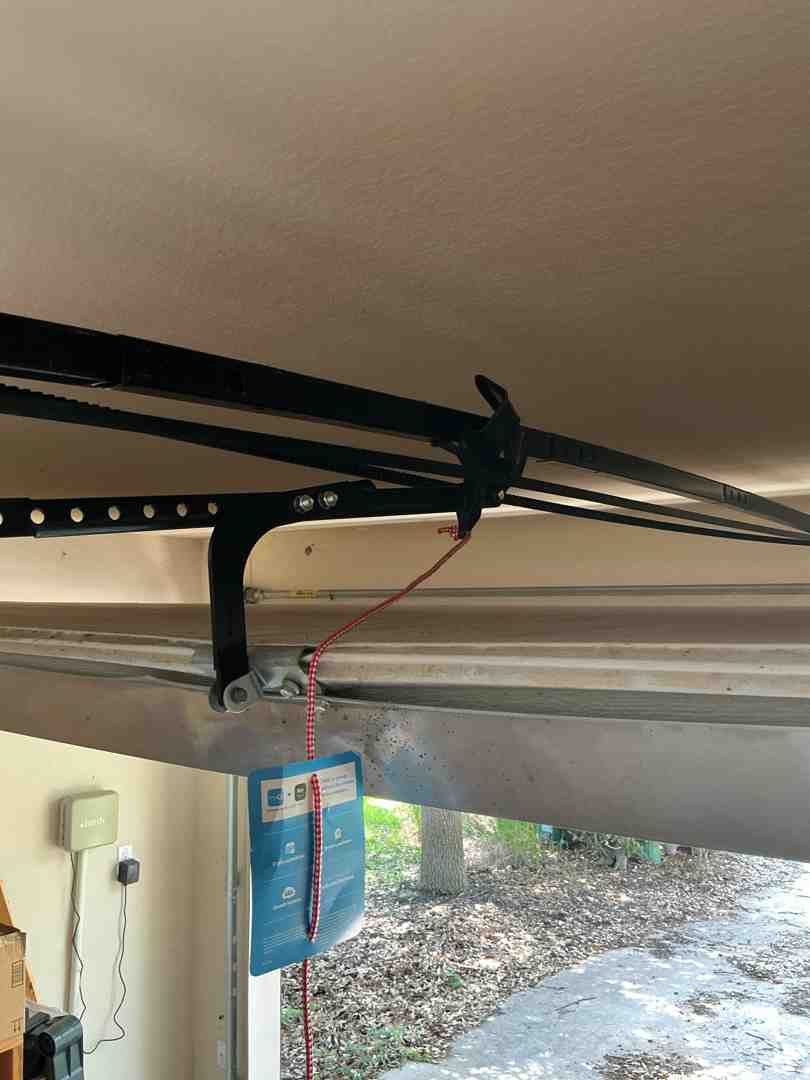 close-up view of garage door opener emergency release handle and track