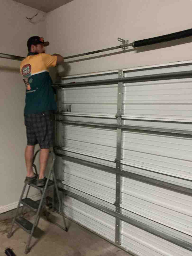 Technician performing a 26-point safety inspection on a garage door system - garage door opener repair service in liberty