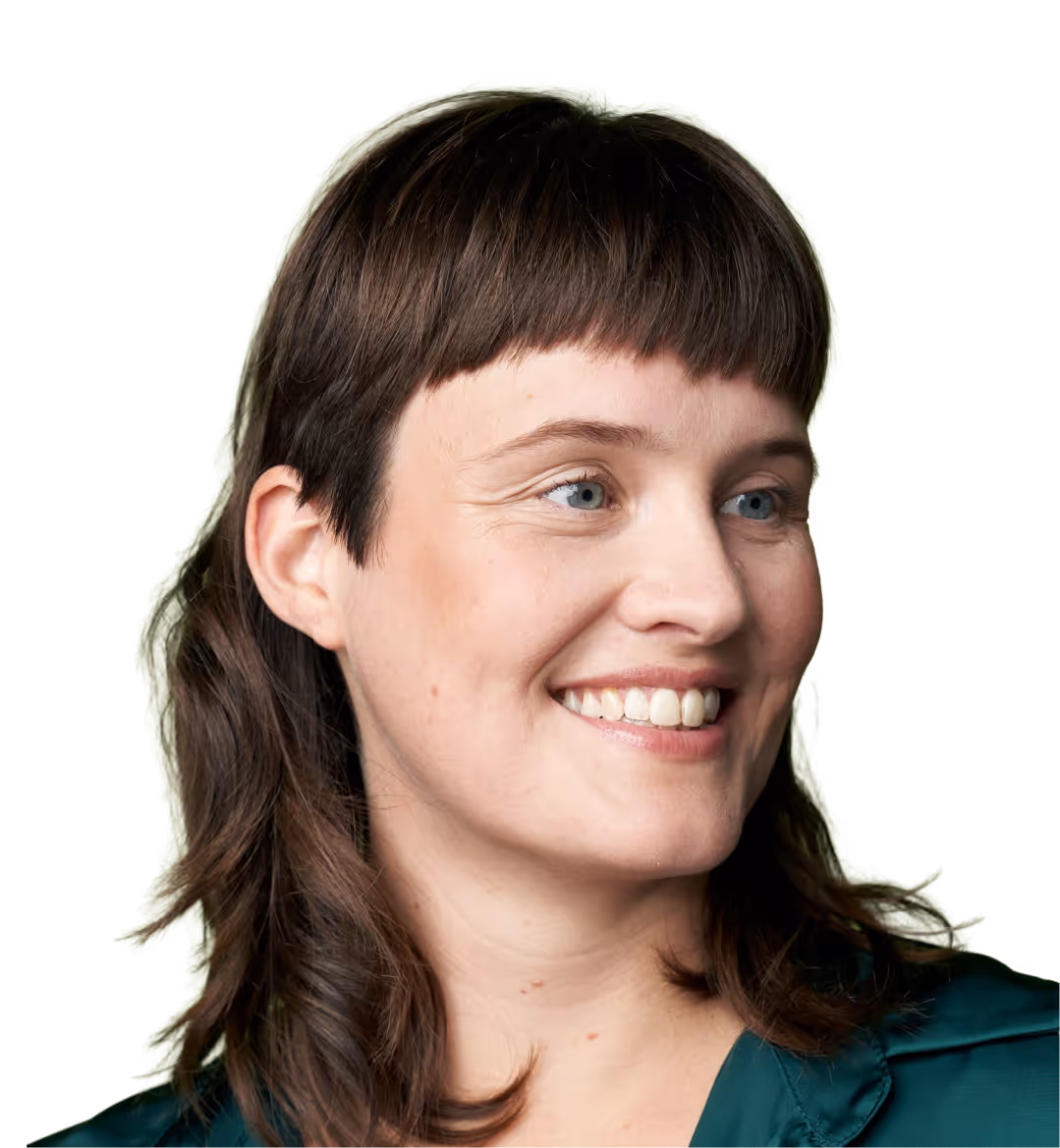 Smiling woman with brown hair and bangs, looking to the right.