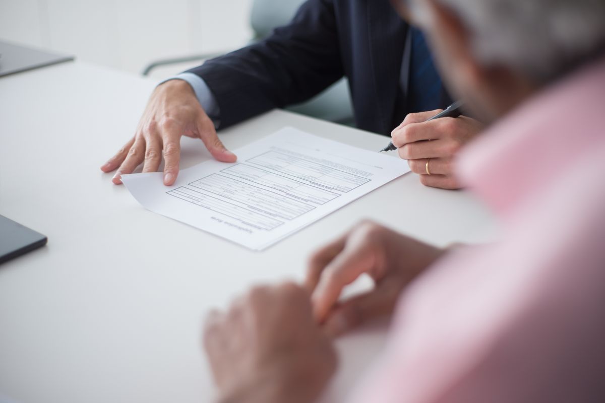 Two people signing a civil-law contract at a desk