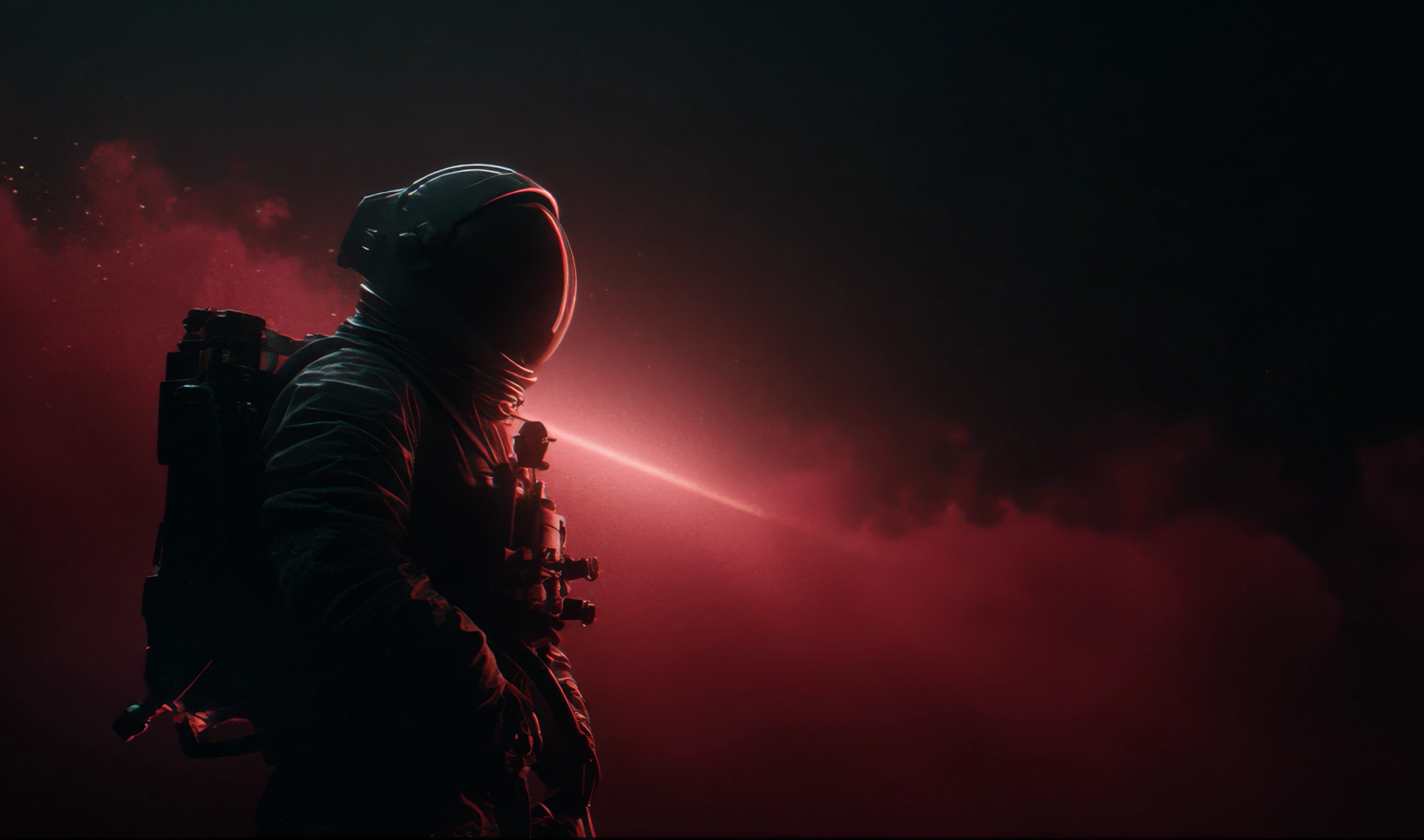 Silhouette of an astronaut illuminated by a red light beam and surrounded by red smoke against a dark background.