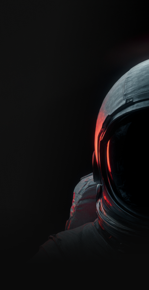 Close-up of an astronaut helmet and upper suit illuminated with red light on a dark background.